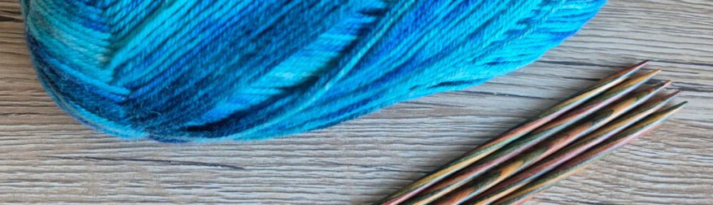Set aus Holzstricknadeln und buntem Sockengarn für Anfänger