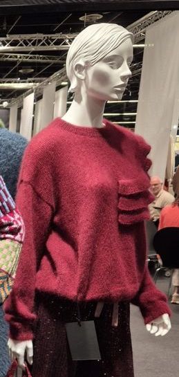 Nahaufnahme eines gestrickten Pullovers aus flauschigem Garn auf der Handarbeitsmesse.