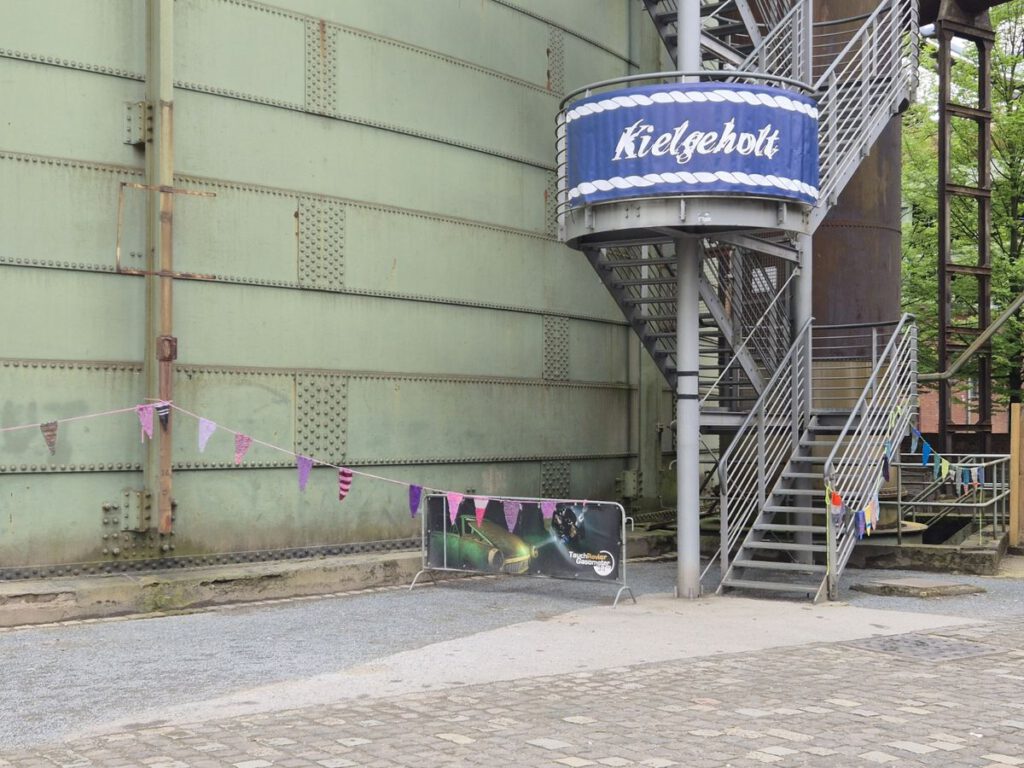 Großes blaues Banner am Eingang des Wollfests Kielgeholt in Duisburg mit dem Veranstaltungslogo
