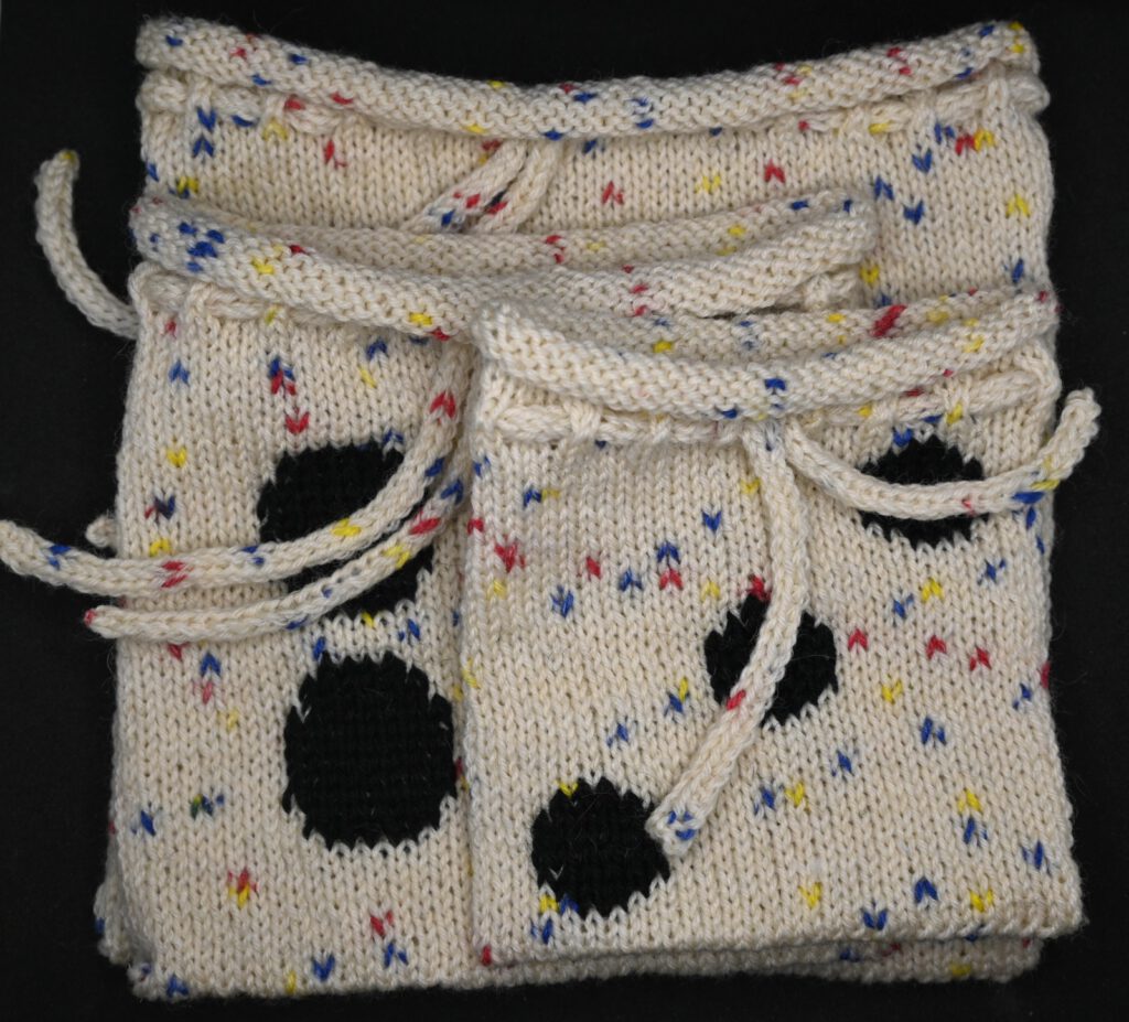 Nahaufnahme eines gestrickten Würfelbeutels mit eingestrickten Würfelaugen